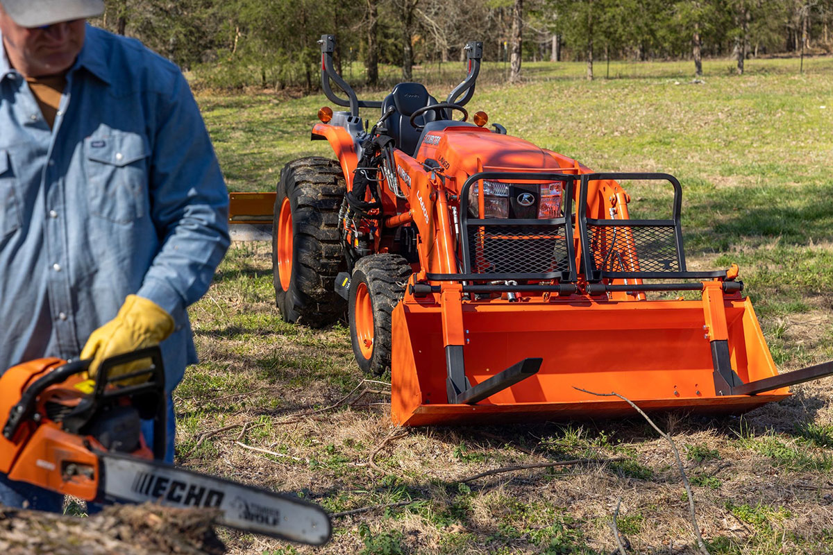 Man standing in front of forks on a Bucket Pro by Battle Armor Designs